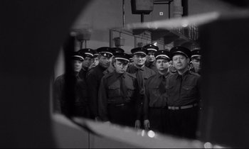 Movie still from “The Hole” (1960), directed by Jacques Becker – Black and white photograph of a group of men in uniform; Medium shot, Low angle