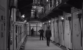Movie still from “The Hole” (1960), directed by Jacques Becker – Two men are walking down a hallway in a prison; Wide shot, High angle