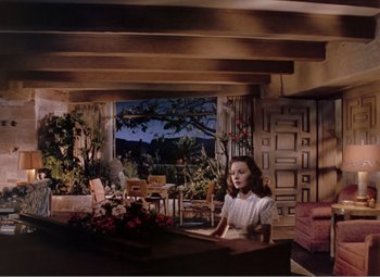 Movie still from “Leave Her to Heaven” (1945), directed by John M. Stahl – A woman sitting at a table in front of a window; Wide shot, High angle
