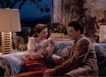 Movie still from “Leave Her to Heaven” (1945), directed by John M. Stahl – A man and a woman sitting on a couch together; Medium shot, High angle