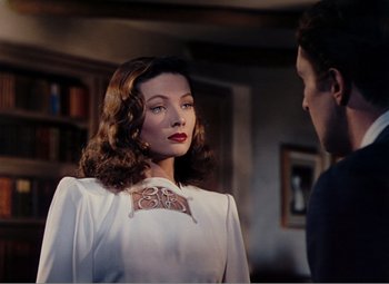 Movie still from “Leave Her to Heaven” (1945), directed by John M. Stahl – A woman in a white dress is talking to a man in a room; Close Up shot, Over the shoulder angle