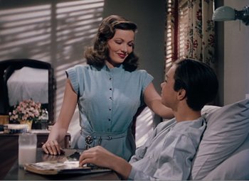 Movie still from “Leave Her to Heaven” (1945), directed by John M. Stahl – A woman standing next to a man at a table; Medium shot, High angle