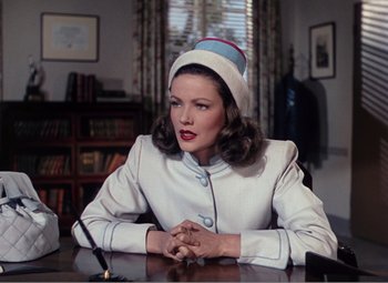 Movie still from “Leave Her to Heaven” (1945), directed by John M. Stahl – A woman sitting at a table wearing a hat; Medium shot, Low angle