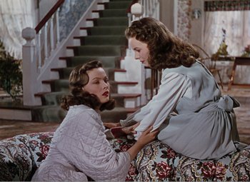 Movie still from “Leave Her to Heaven” (1945), directed by John M. Stahl – Two young women sitting on a couch in front of a staircase; Medium shot, Overhead angle