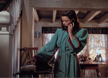 Movie still from “Leave Her to Heaven” (1945), directed by John M. Stahl – A woman talking on a phone while standing in a room; Medium shot, Low angle