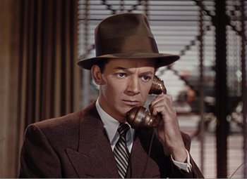 Movie still from “Leave Her to Heaven” (1945), directed by John M. Stahl – A man in a suit and hat talking on a phone; Close Up shot, High angle