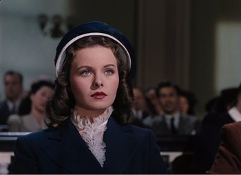 Movie still from “Leave Her to Heaven” (1945), directed by John M. Stahl – A young woman in a blue suit and a white hat; Close Up shot, Low angle