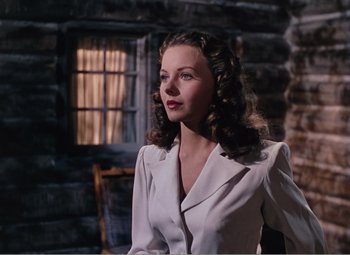 Movie still from “Leave Her to Heaven” (1945), directed by John M. Stahl – A beautiful woman in a white dress standing in front of a window; Medium shot, Low angle