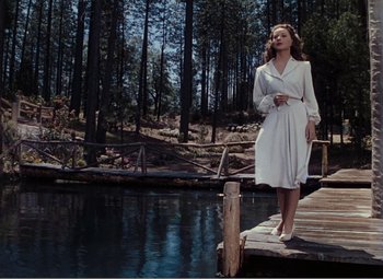 Movie still from “Leave Her to Heaven” (1945), directed by John M. Stahl – A woman standing on a dock near a body of water; Wide shot, Low angle