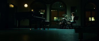 Movie still from “Whiplash” (2014), directed by Damien Chazelle – A room with a piano and drums in it; Extreme Wide shot, High angle