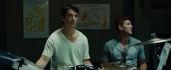 Movie still from “Whiplash” (2014), directed by Damien Chazelle – A man sitting in front of another man in a room; Medium shot, Low angle