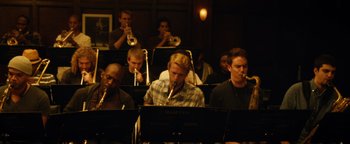 Movie still from “Whiplash” (2014), directed by Damien Chazelle – A group of men sitting in front of microphones; Medium shot, High angle