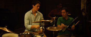 Movie still from “Whiplash” (2014), directed by Damien Chazelle – Two men are playing drums in front of a band; Medium shot, Over the shoulder angle