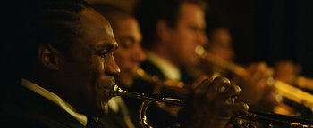Movie still from “Whiplash” (2014), directed by Damien Chazelle – A group of men playing trumpets in front of a crowd; Extreme Close Up shot, Low angle