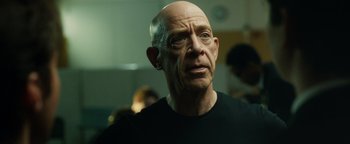 Movie still from “Whiplash” (2014), directed by Damien Chazelle – An older bald man looking into the distance; Close Up shot, Over the shoulder angle