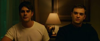 Movie still from “Whiplash” (2014), directed by Damien Chazelle – A man sitting in front of a lamp in a room; Close Up shot, Over the shoulder angle