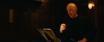 Movie still from “Whiplash” (2014), directed by Damien Chazelle – An older man is sitting in front of a sheet of paper; Close Up shot, Low angle