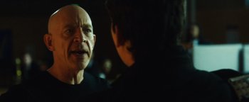 Movie still from “Whiplash” (2014), directed by Damien Chazelle – A man talking to another man in a dark room; Close Up shot, Over the shoulder angle