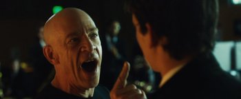 Movie still from “Whiplash” (2014), directed by Damien Chazelle – A man with a bald head is talking to another man; Close Up shot, Over the shoulder angle