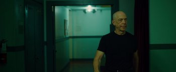 Movie still from “Whiplash” (2014), directed by Damien Chazelle – A man standing in a hallway with a light on; Medium shot, Low angle