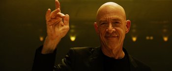 Movie still from “Whiplash” (2014), directed by Damien Chazelle – A man with a bald head is giving a peace sign; Close Up shot, Low angle