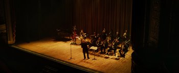 Movie still from “Whiplash” (2014), directed by Damien Chazelle – A group of people on a stage with instruments; Extreme Wide shot, High angle