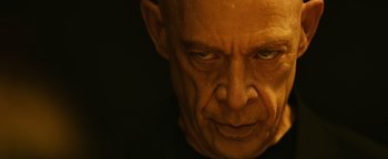 Movie still from “Whiplash” (2014), directed by Damien Chazelle – An older man with a bald head and a black shirt; Close Up shot, Low angle