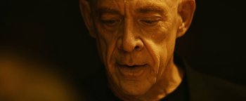 Movie still from “Whiplash” (2014), directed by Damien Chazelle – An older man with a bald head and a black shirt; Close Up shot, Low angle
