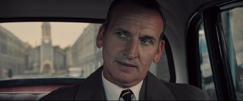 Movie still from “Legend” (2015), directed by Brian Helgeland – A man in a suit and tie in a car; Close Up shot, Over the shoulder angle