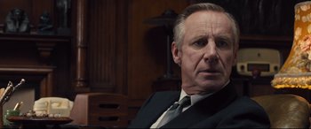 Movie still from “Legend” (2015), directed by Brian Helgeland – A person wearing a suit and tie; Close Up shot, Over the shoulder angle
