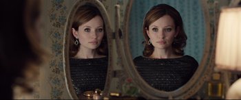 Movie still from “Legend” (2015), directed by Brian Helgeland – A woman looking in the mirror in front of a mirror; Close Up shot, Over the shoulder angle