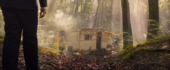 Movie still from “Legend” (2015), directed by Brian Helgeland – An old trailer in the middle of a forest; Extreme Wide shot, High angle