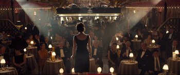 Movie still from “Legend” (2015), directed by Brian Helgeland – A group of people sitting in a room with lights; Wide shot, Over the shoulder angle