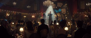 Movie still from “Legend” (2015), directed by Brian Helgeland – A group of people sitting in a room with a microphone; Wide shot, Over the shoulder angle