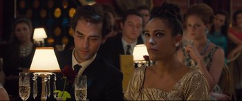 Movie still from “Legend” (2015), directed by Brian Helgeland – A man and a woman sitting next to each other at an event; Close Up shot, Over the shoulder angle