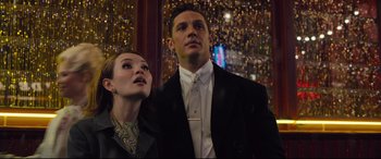 Movie still from “Legend” (2015), directed by Brian Helgeland – A man and a woman standing next to each other; Close Up shot, Low angle
