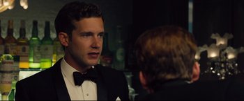 Movie still from “Legend” (2015), directed by Brian Helgeland – A man in a tuxedo talking to another man in a suit; Close Up shot, Over the shoulder angle
