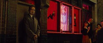 Movie still from “Legend” (2015), directed by Brian Helgeland – A man standing in front of a window in a bar; Medium shot, Over the shoulder angle