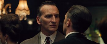 Movie still from “Legend” (2015), directed by Brian Helgeland – A man wearing a suit and tie talking to another man wearing a suit and tie; Close Up shot, Over the shoulder angle