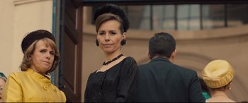 Movie still from “Legend” (2015), directed by Brian Helgeland – A woman in a black dress and a black hat; Close Up shot, Over the shoulder angle