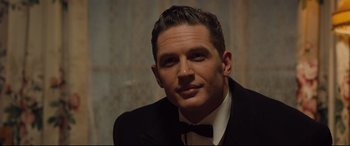 Movie still from “Legend” (2015), directed by Brian Helgeland – A person wearing a suit and bow tie; Close Up shot, Over the shoulder angle