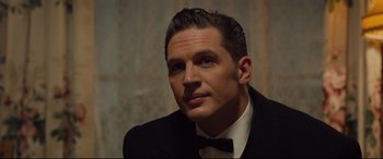 Movie still from “Legend” (2015), directed by Brian Helgeland – A person wearing a suit and bow tie; Close Up shot, Over the shoulder angle