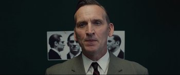 Movie still from “Legend” (2015), directed by Brian Helgeland – A person wearing a suit and tie; Close Up shot, Over the shoulder angle