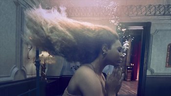 Movie still from “Lemonade” (2016), directed by Mark Romanek – A woman with her hair blowing in the wind; Medium shot, Overhead angle