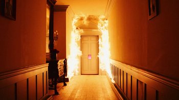 Movie still from “Lemonade” (2016), directed by Mark Romanek – A hallway with a white door lit up with lights; Wide shot, High angle