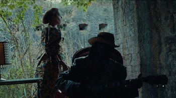 Movie still from “Lemonade” (2016), directed by Mark Romanek – A woman standing next to a man in a hat; Medium shot, Low angle
