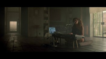 Movie still from “Lemonade” (2016), directed by Mark Romanek – A woman sitting in front of a computer keyboard; Wide shot, High angle