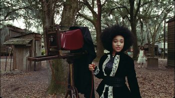 Movie still from “Lemonade” (2016), directed by Mark Romanek – A woman in a black dress standing in front of a camera; Medium shot, Low angle
