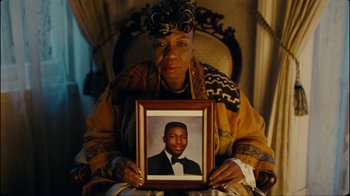 Movie still from “Lemonade” (2016), directed by Mark Romanek – An older woman holding up a picture of a young man; Extreme Close Up shot, High angle