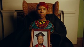 Movie still from “Lemonade” (2016), directed by Mark Romanek – A woman sitting in a chair holding up a picture of a man; Extreme Close Up shot, High angle